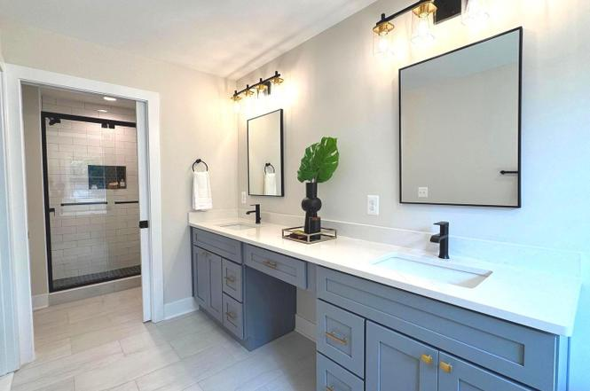 Blue double vanity with shower beyond