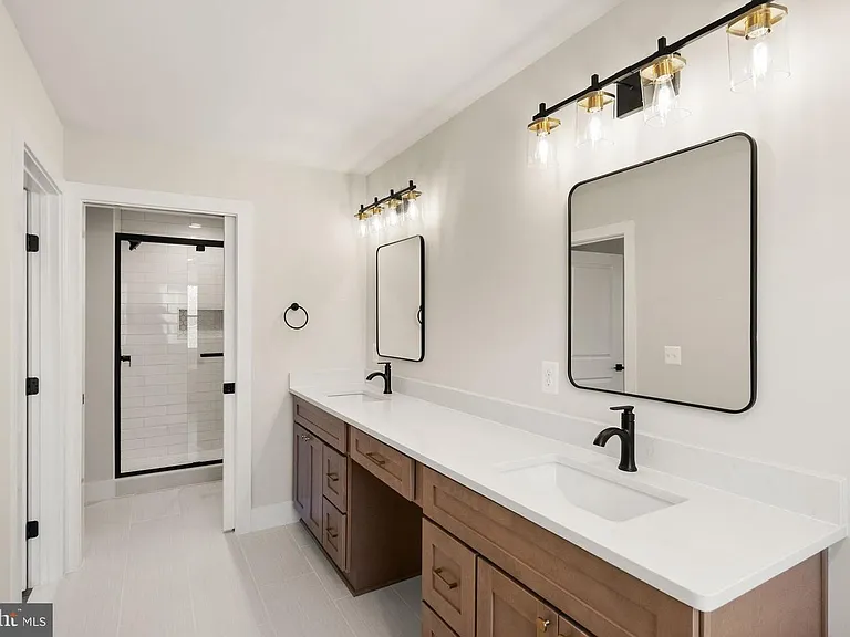 Long bathroom vanity with two mirrors and shower entry