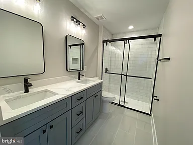 Bathroom with gray vanity and glass shower