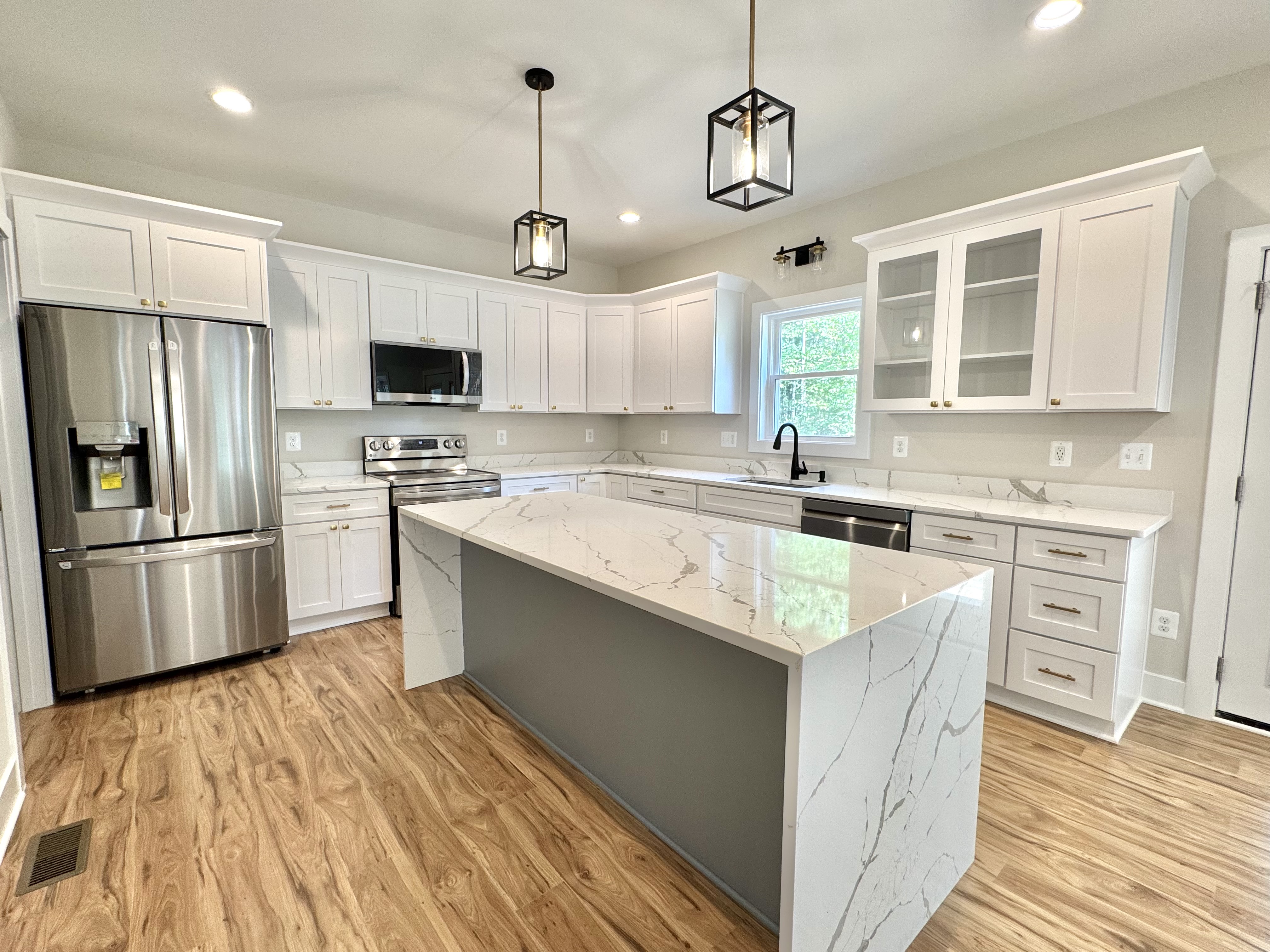 Kitchen with marble island and white cabinetry
